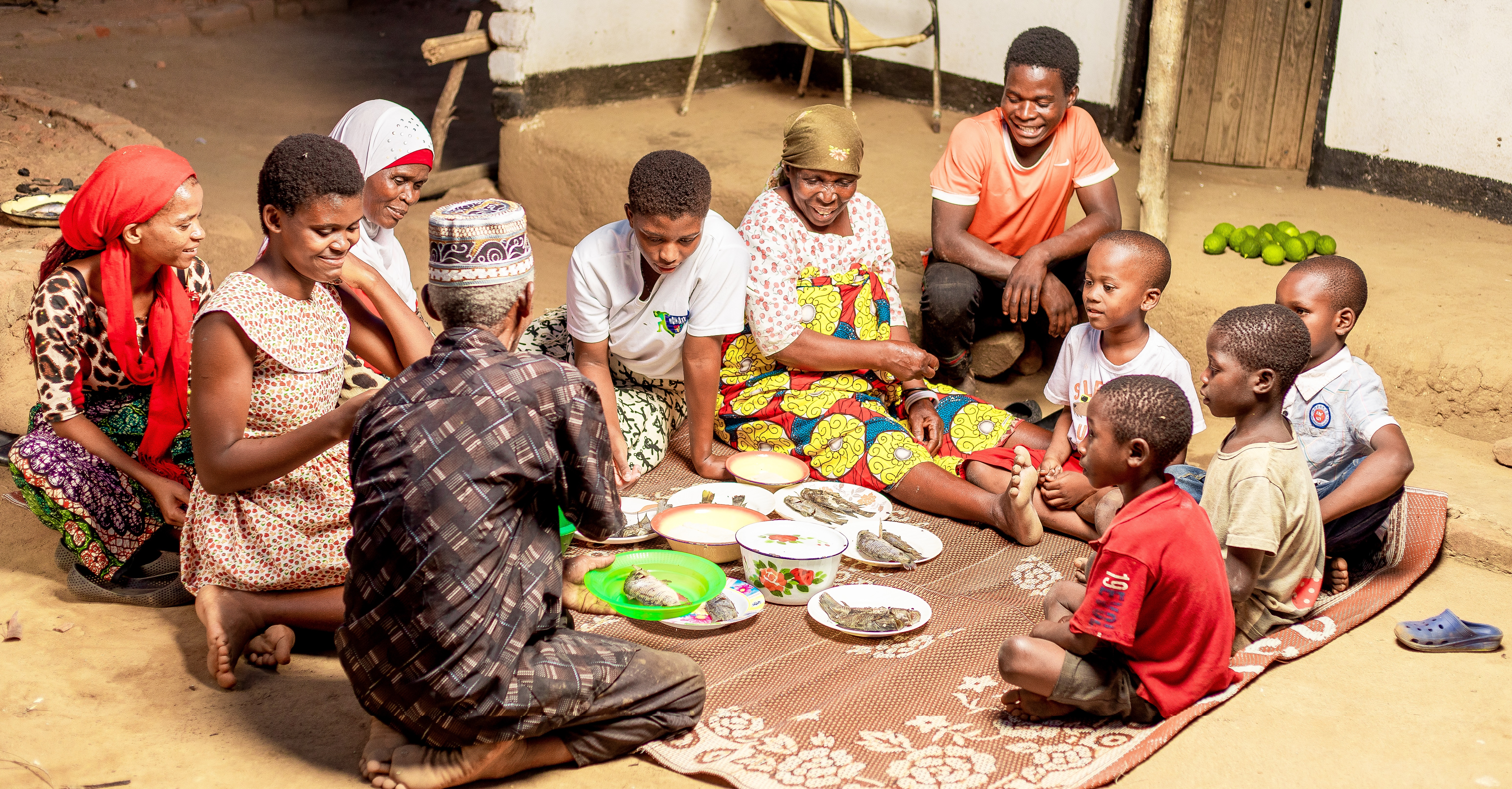 Family eating fish as a meal together, sitting in a circle