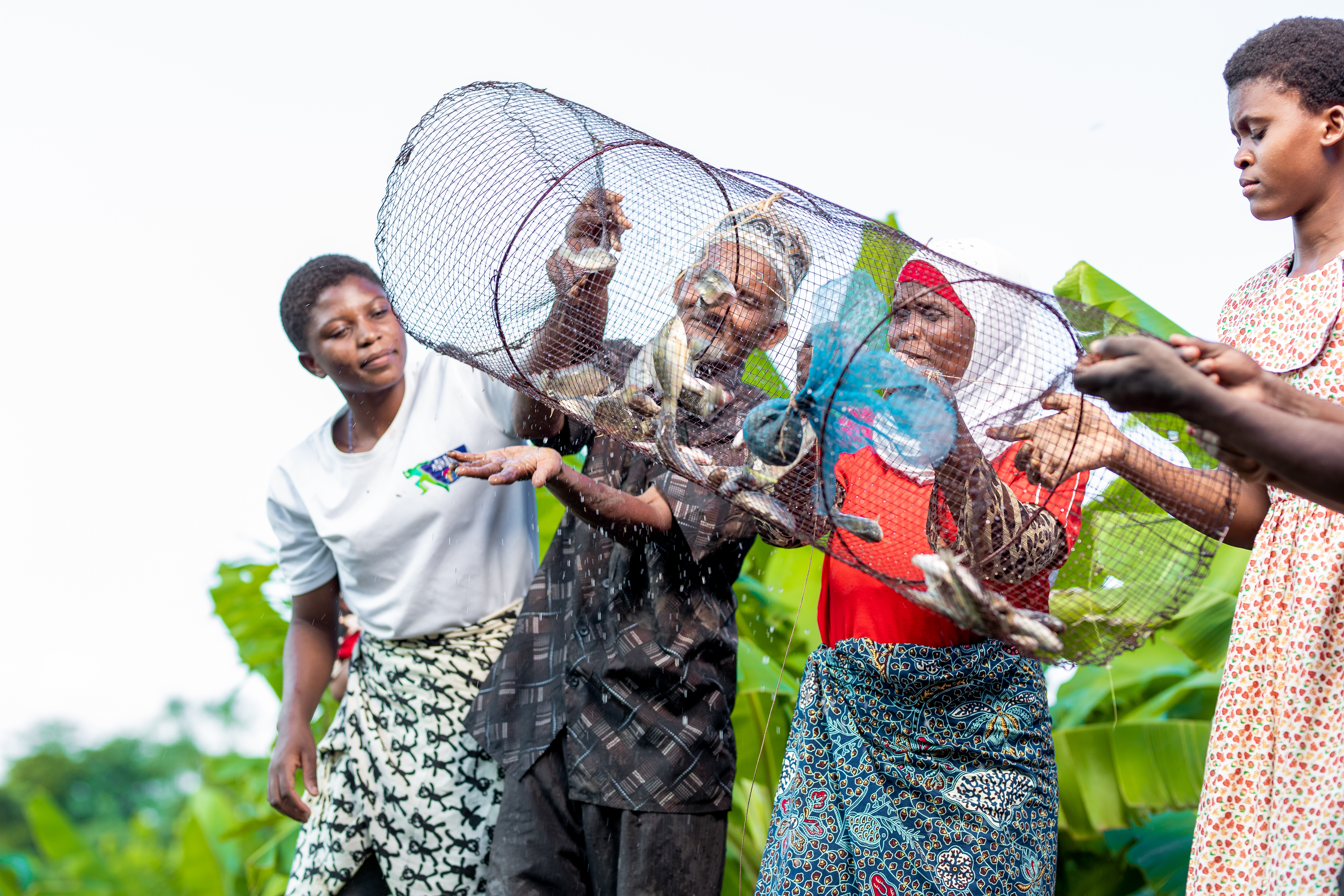 A family of four is showing their catch through the use of the fish trap