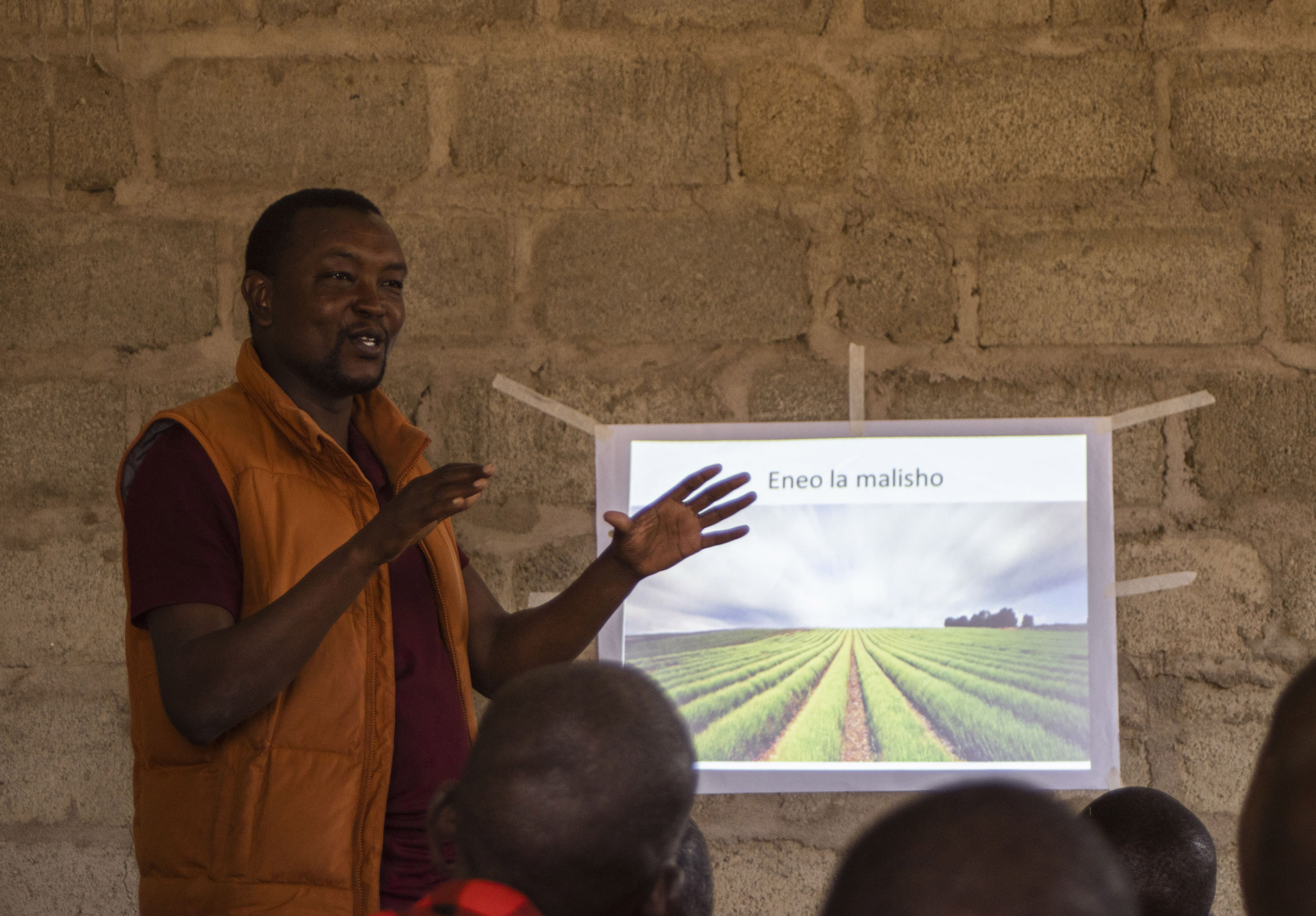 A man stands in front of a presentation projected on to a wall