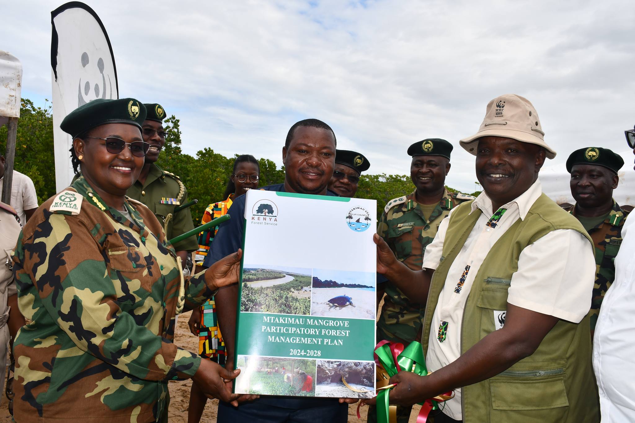 Ms. Beatrice Mbula (DCCF, FCM) and Mr. Nathaniel Mwengeka (WWF-Kenya) officially launch the MTAKIMAU Mangrove Participatory Forest Management Plan (PFMP), joined by the CFA Chairperson during the official launch ceremony.