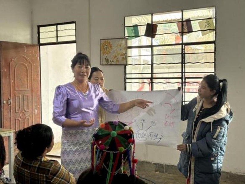 Yang Ruidong (left) shares climate knowledge with local villagers