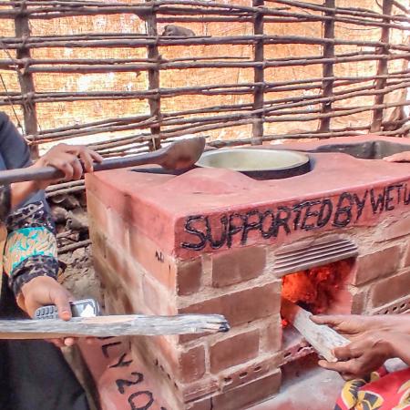 Improved cookstove has reduced Sofia Shee (R) and her daughter Nyebwana Mohamed's cooking time significantly comparable to traditional three-stone stove