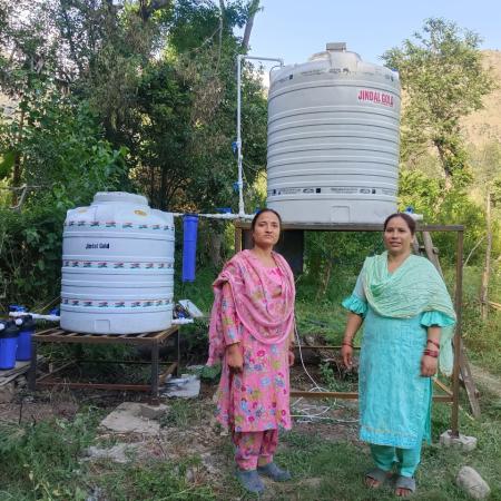Rama devi, with a member of their group in front their biofermenter in Kullu, Himachal Pradesh