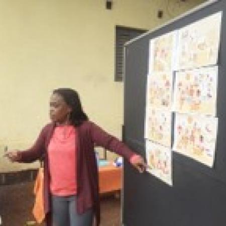 Inès Sea showing illustrated cards during a training of women cooperatives