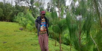 Beneficiary standing in his plantation site. 