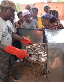 A women-led fish farmer group in Malawi receives training on the climate-friendly Chitofu 3-in-1 stove